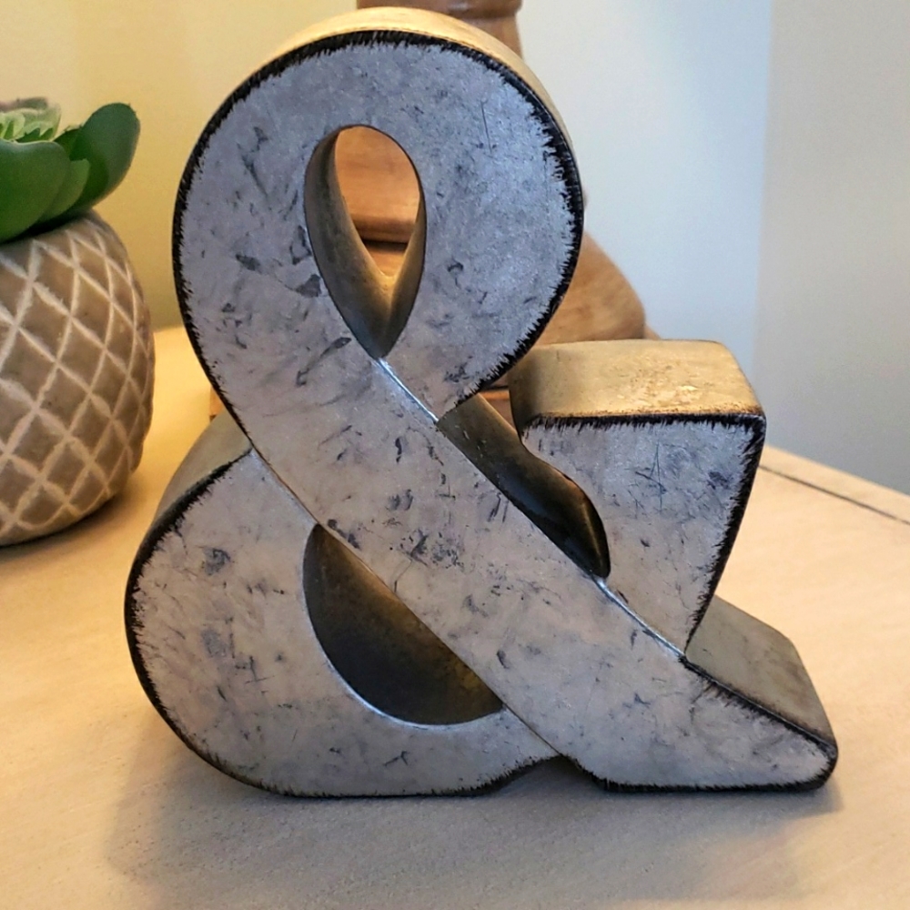 Silver pitted "&" tabletop sign.
